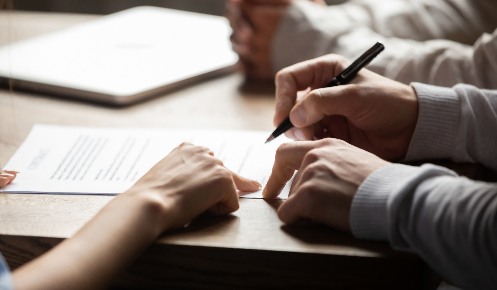 Solicitor pointing at contract showing client where to write signature